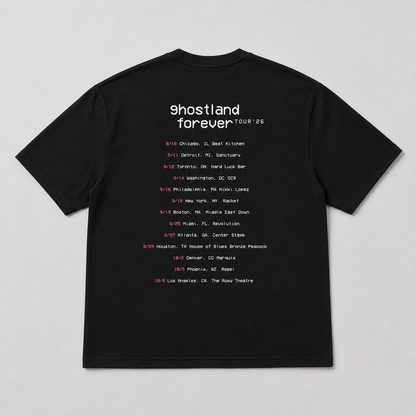 A black short-sleeve t-shirt laid flat against a light gray background, featuring a white and pink printed concert tour schedule for Ghostland Forever Tour '26 on the front.