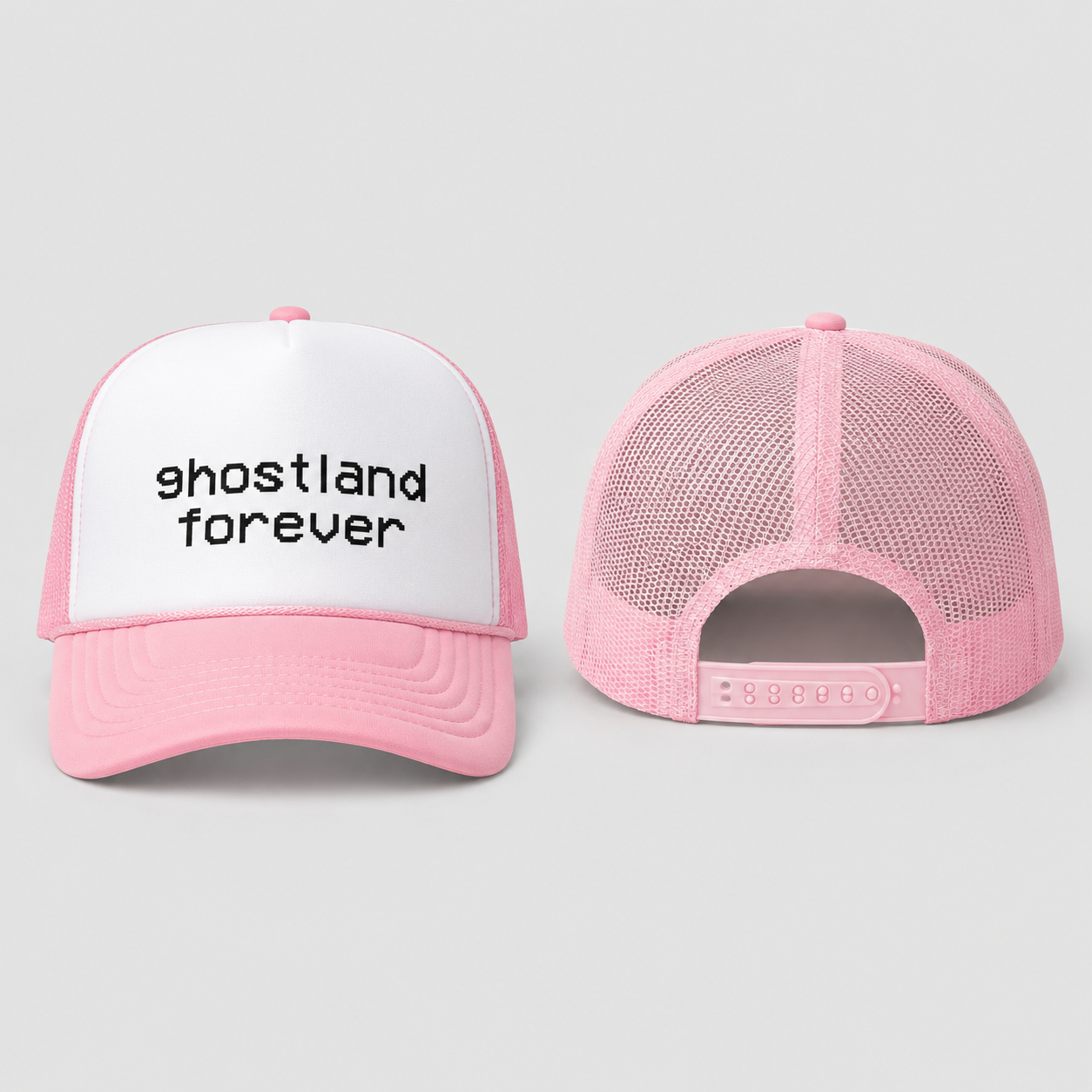 A pink and white trucker hat shown from the front and back on a light gray background. The front panel is white with the text 'ghostland forever' in black lowercase letters, and the brim and mesh back are pink.
